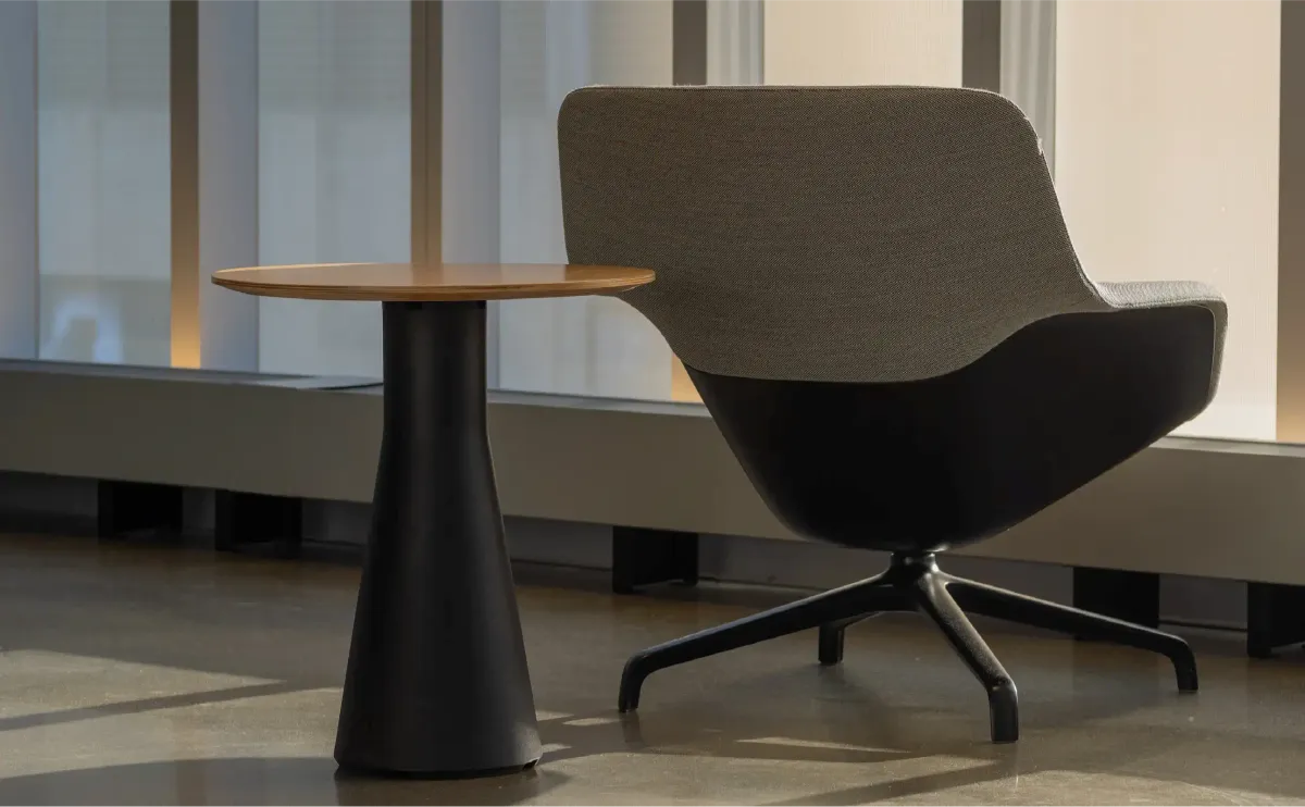 Sculptural lounge chair and side table in a quiet interior
