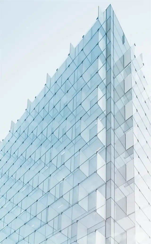 Glass institutional headquarters viewed against a pale sky