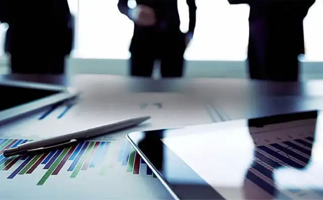 Advisers reviewing financial analysis around a meeting table