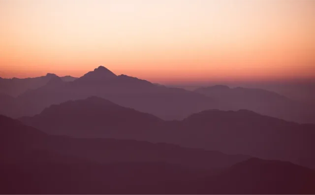 Layered mountain horizon at sunrise suggesting speed and forward motion